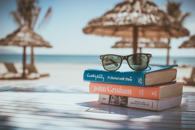 3 books on a wooden table on a beach